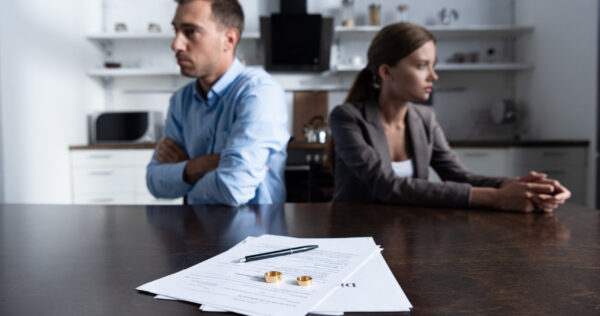 selective focus of couple sitting at table with divorce documents